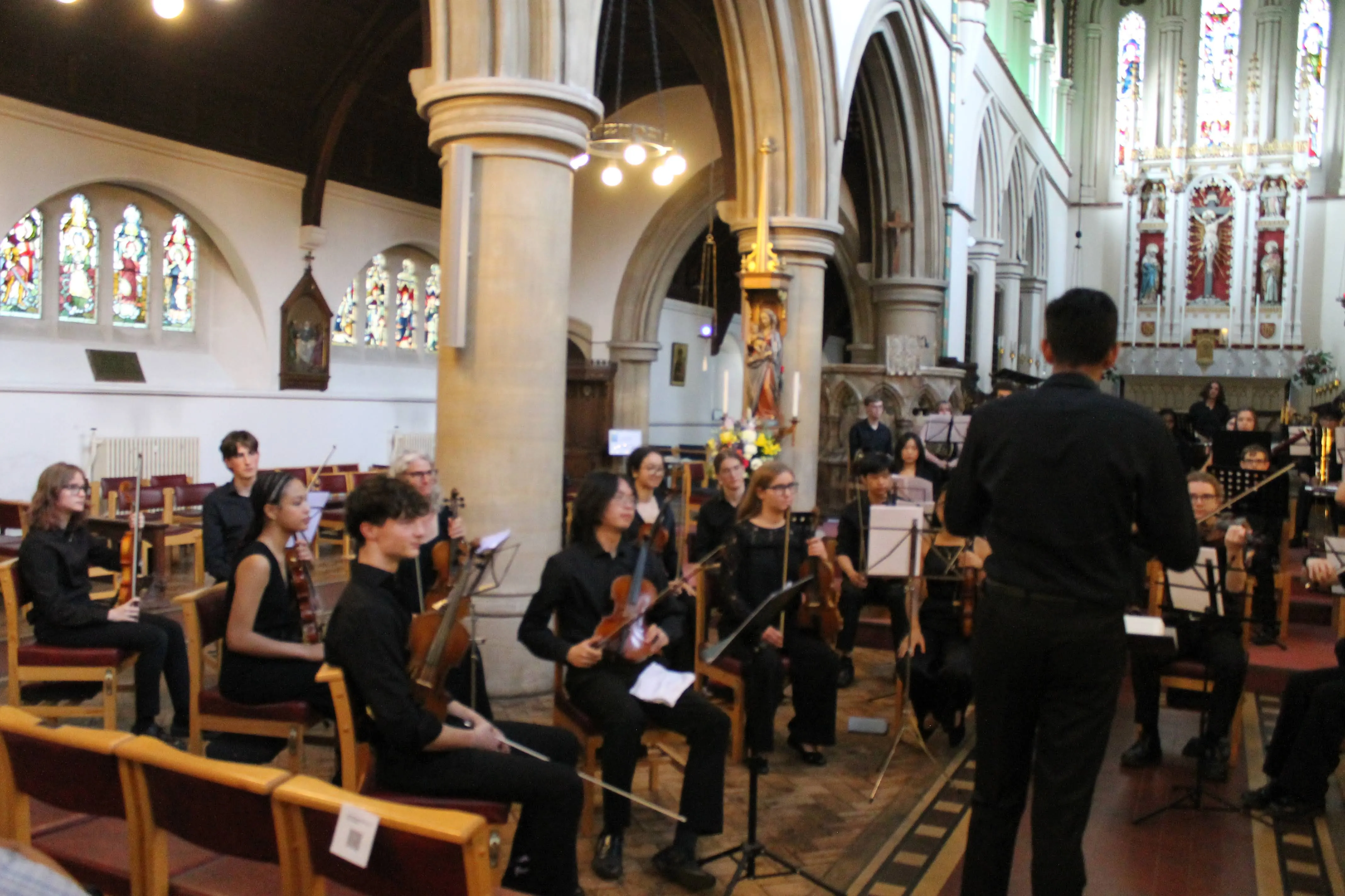 Titan Sinfonia performing beneath stained-glass windows