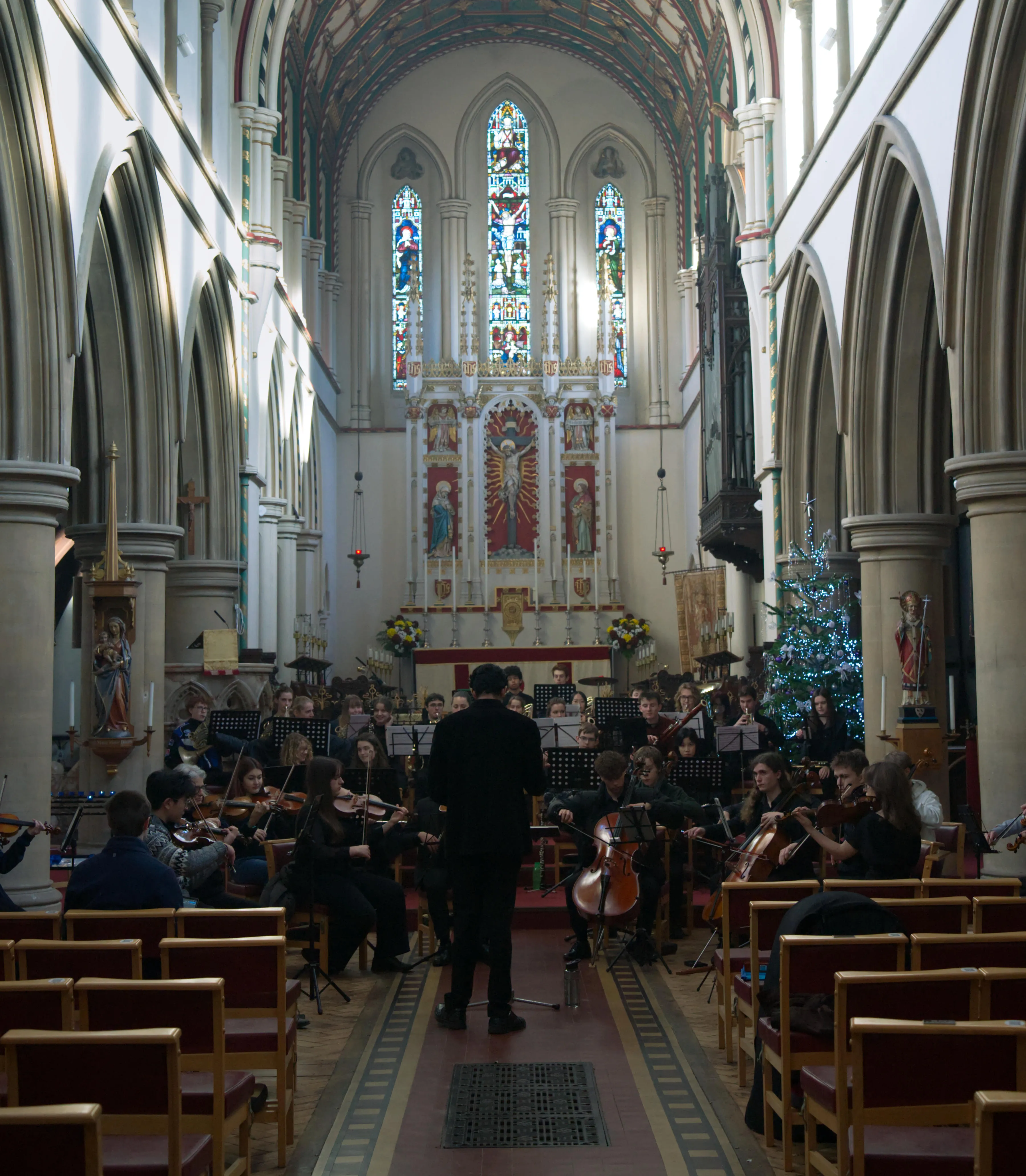 The full orchestra beneath the church's vaulted ceiling and stained glass.